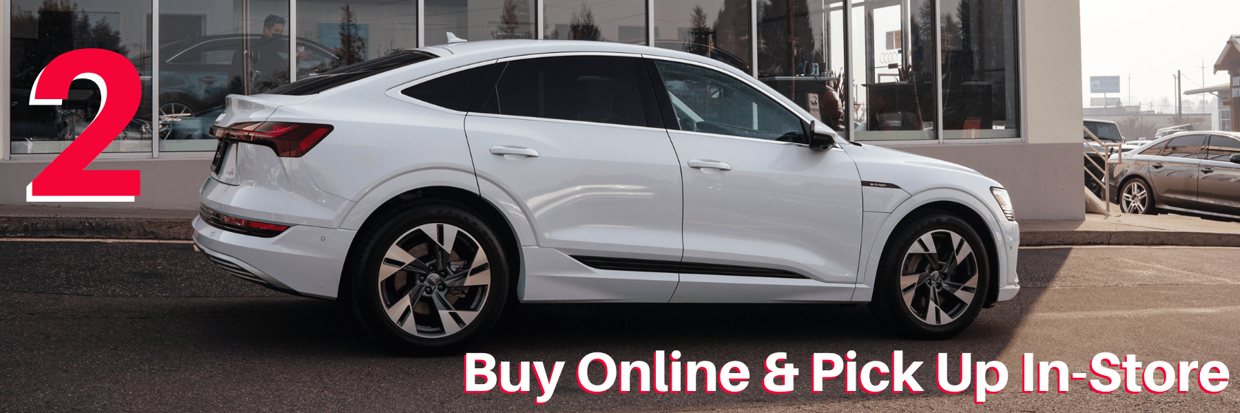 white audi in front of dealership